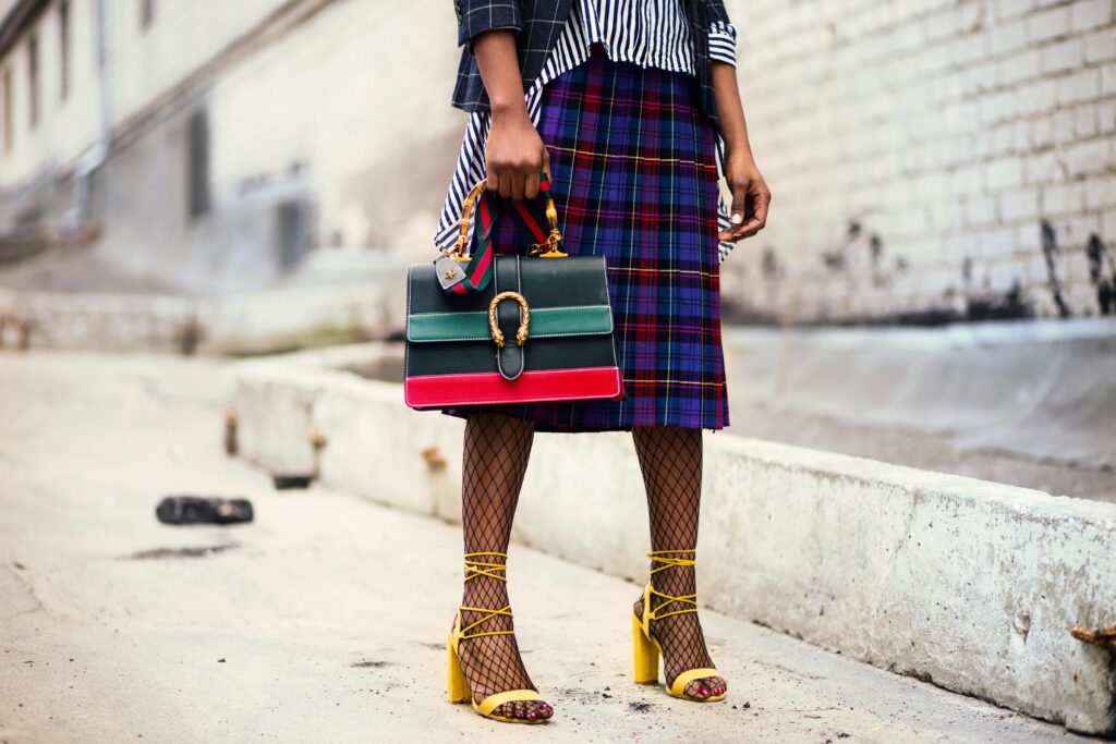 Which Place Is Famous for Fashion? A Guide to the World’s Top Fashion Capitals Fashion-forward outfit with plaid skirt and colorful handbag in urban setting.